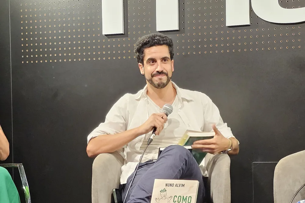 Nuno Alvim a falar ao microfone durante a apresentação do livro na Fnac NorteShopping, no Porto.